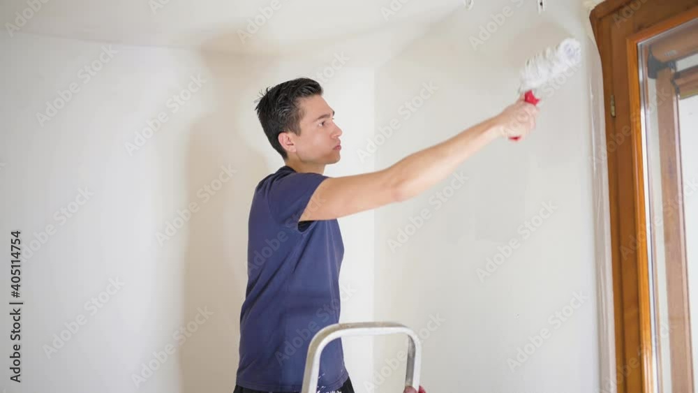Man painting walls with paint roller. Handyman, home refurbishing and renovate concept.