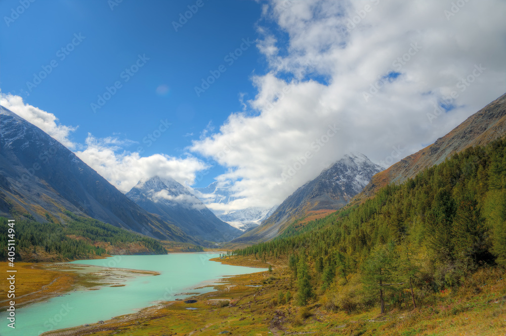 A beautiful lake in a mountain valley. Mountains covered with snow.