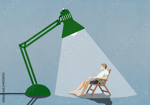 Man sitting under bright sun lamp
