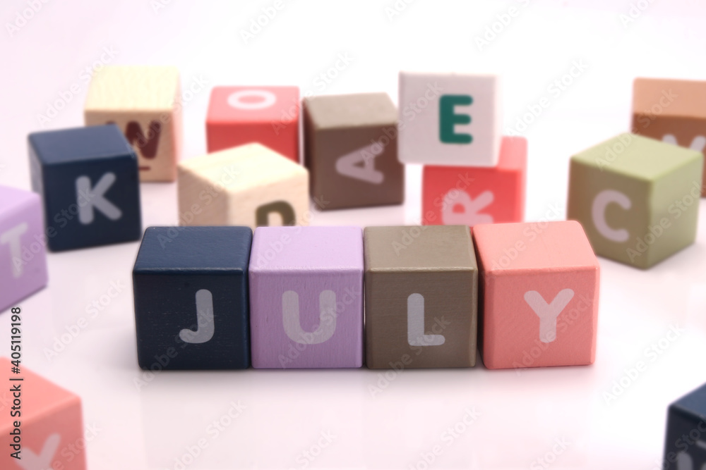 Cubes each with a letter on it written the word July Cubes each with a letter on it written the word July