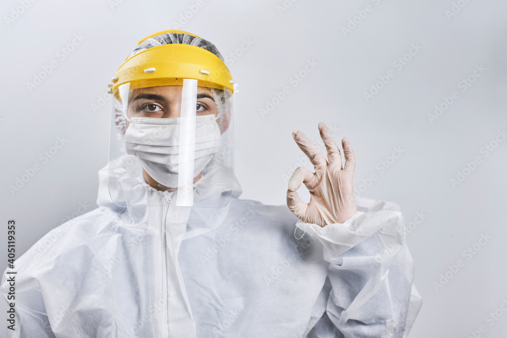 Portrait of a doctor fighting against Coronavirus. A nurse in medical protective wear looking at camera. Health care worker showing OK or Fine handgesture Portrait of a doctor fighting against Coronavirus. A nurse in medical protective wear looking at camera. Health care worker showing OK or Fine handgesture