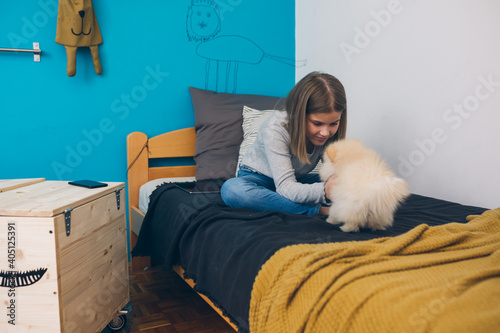 little girl playing with her puppy at home