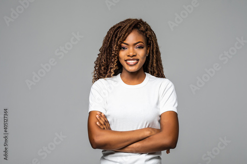 Joyful African American student keeps hands crossed isolated over white background.
