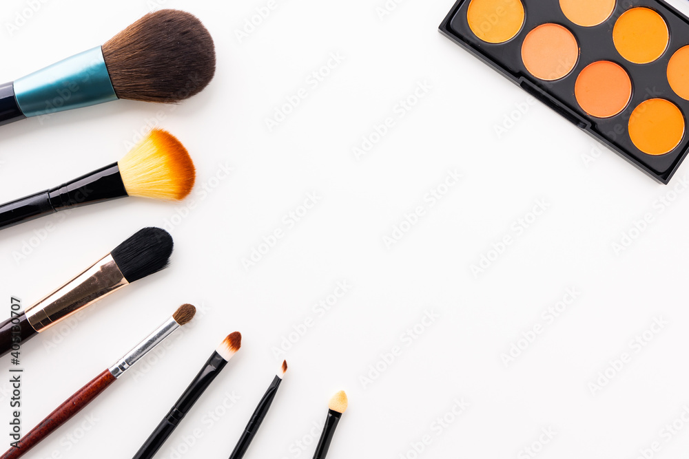 Plenty of makeup on the white table with eyelash brush, eye shadow, lipstick with copy space for text. Plenty of makeup on the white table with eyelash brush, eye shadow, lipstick with copy space for text.