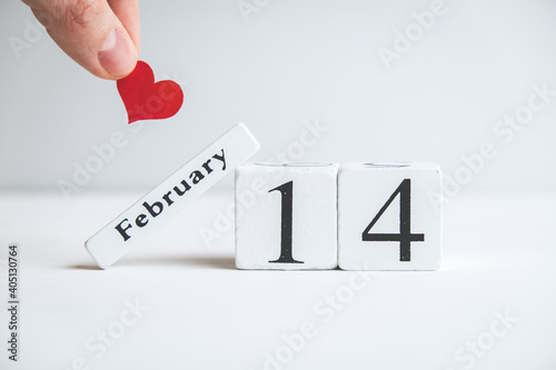 Hand holding heart over february 14 on valentine day