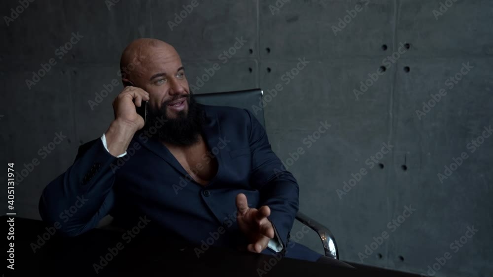 busy man is negotiating by cell phone sitting in his home office, sexy muscular guy, portrait indoors busy man is negotiating by cell phone sitting in his home office, sexy muscular guy, portrait indoors