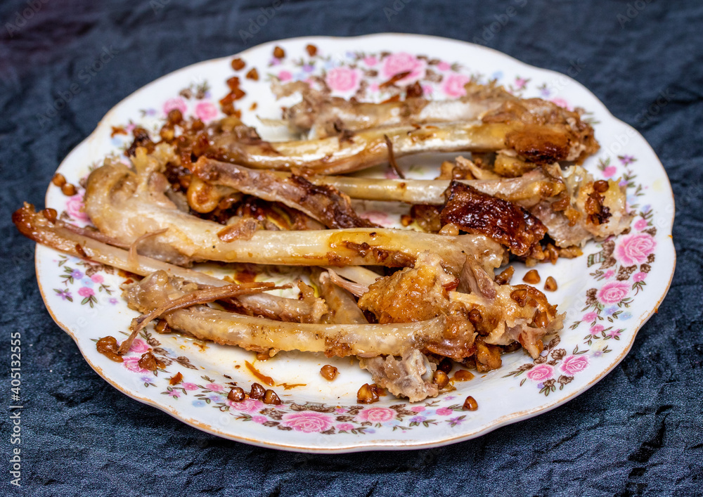 Chicken bones in plates on the table. Chicken bones in plates on the table.