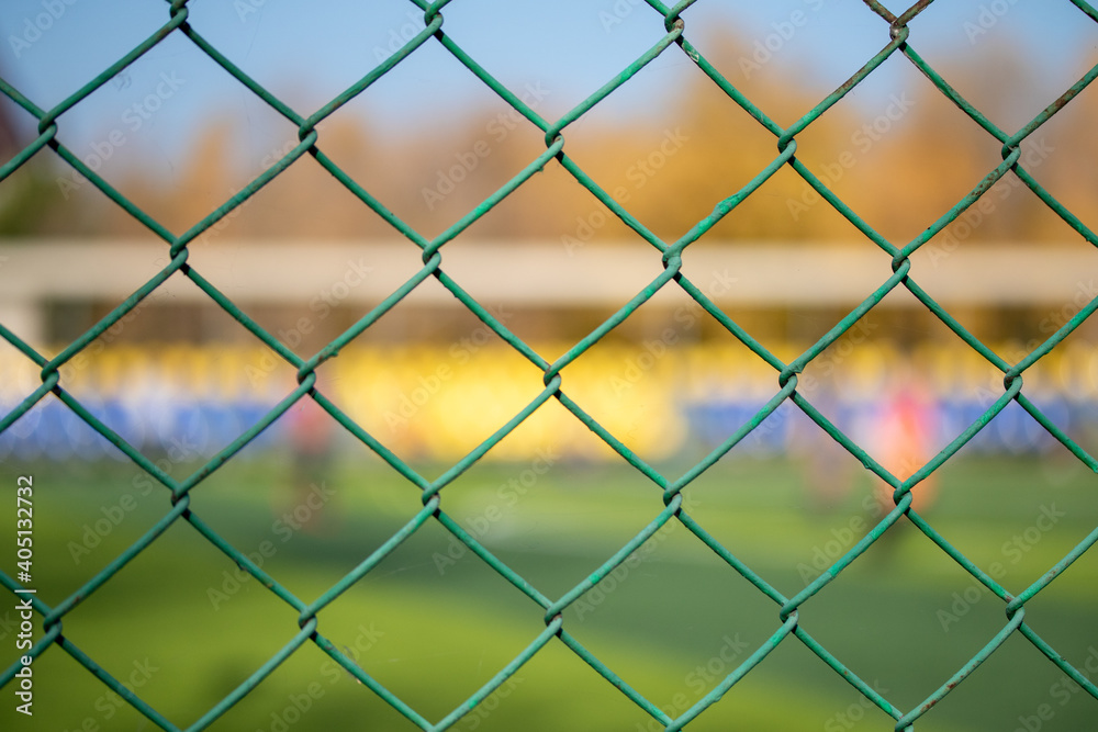 Green metal mesh near the football field. Green metal mesh near the football field.