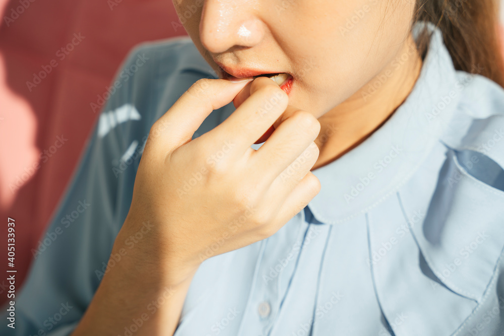 Asian woman bitting nail. Portrait of worried scared woman in formal shirt. Asian woman bitting nail. Portrait of worried scared woman in formal shirt.