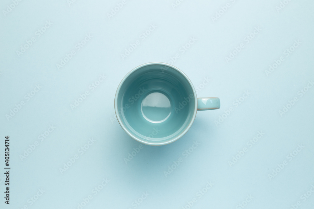 Empty mug cup on sky blue background. top view, copy space