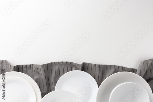 The white table had a white empty plate over the tablecloth. Place for placing text.