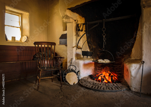 Fotografia, Obraz The wooden chair in the old style antique vintage kitchen with tools and firepla