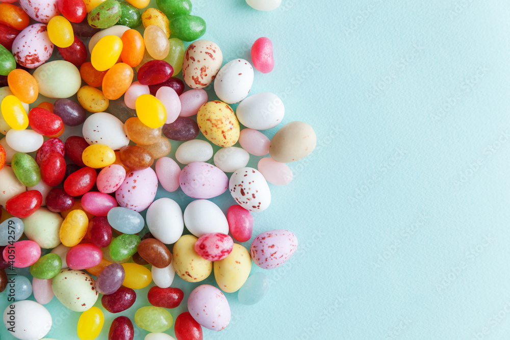 Happy Easter concept. Preparation for holiday. Easter candy chocolate eggs and jellybean sweets isolated on trendy pastel blue background. Simple minimalism flat lay top view copy space. Happy Easter concept. Preparation for holiday. Easter candy chocolate eggs and jellybean sweets isolated on trendy pastel blue background. Simple minimalism flat lay top view copy space.