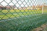 Green metal mesh near the football field.