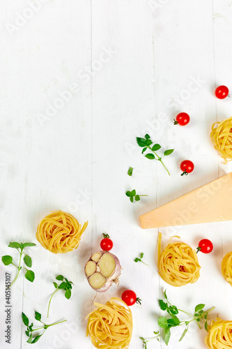 Ingredients for cooking pasta - tagliatelle, tomato, garlic, basil, parmesan cheese