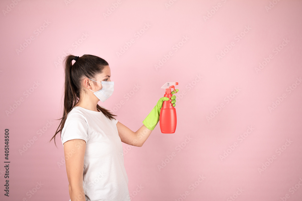 Woman in protective mask and gloves holding spray sanitizer bottle. Disinfection prevention concept. Home cleaning chores. Woman hand armed with atomizer. Woman in protective mask and gloves holding spray sanitizer bottle. Disinfection prevention concept. Home cleaning chores. Woman hand armed with atomizer.