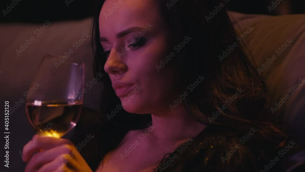 young brunette woman drinking white wine on dark background young brunette woman drinking white wine on dark background