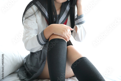 Portrait japanese school girl sitting in white tone bedroom