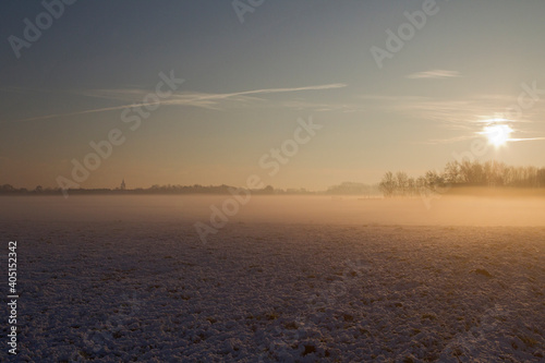 Weiland met sneeuw en zonsopkomst  Meadow with snow in sunrise