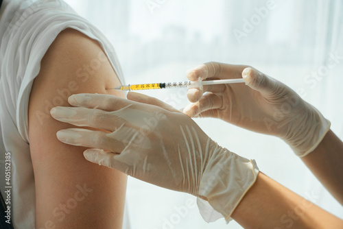 Doctor help people who got infect by covid-19 virus by inject vaccine at arm shoulder.