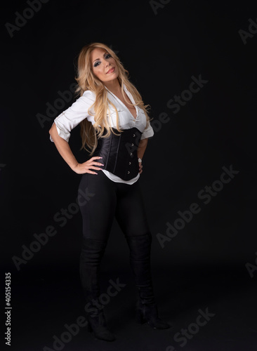 Beautiful middle aged blonde european model posing in studio on black background.