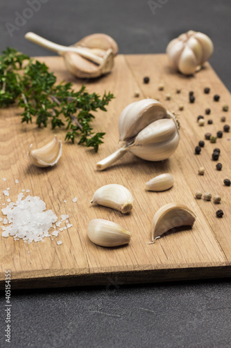 Heads and cloves of garlic, allspice and salt on cutting board