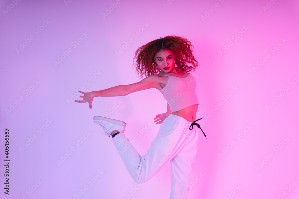 Active asian curly hair girl dancing in neon light at studio indoors. Active asian curly hair girl dancing in neon light at studio indoors.
