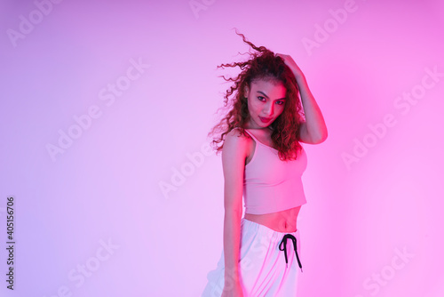 Beautiful asian girl with an afro curly hairstyle in neon light studio.