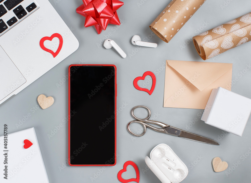 Red Mobile phone and valentines day decorations near laptop Red Mobile phone and valentines day decorations near laptop