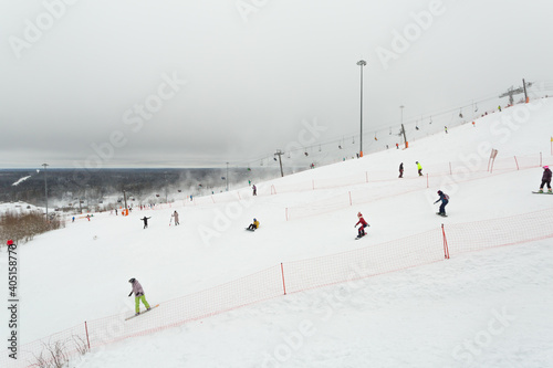 Scenic panorama with skiers and snowboarders on the slope of Saint Petersburg, Russia.