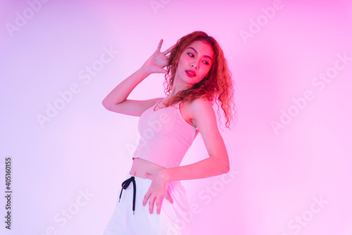 Portrait of asian woman curly hairstyle posing in neon light studio.