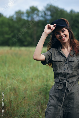 Woman in green jumpsuit smiling in the field 