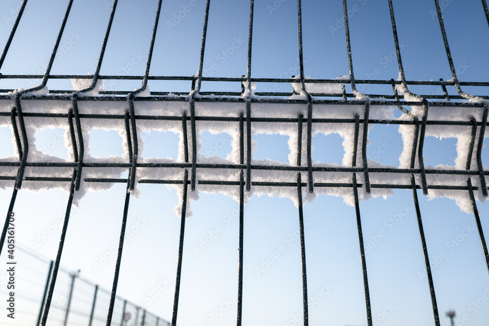 metal mesh in the snow against the blue sky metal mesh in the snow against the blue sky