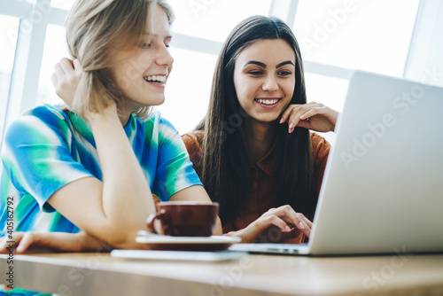 Female friends sharing laptop spending time together