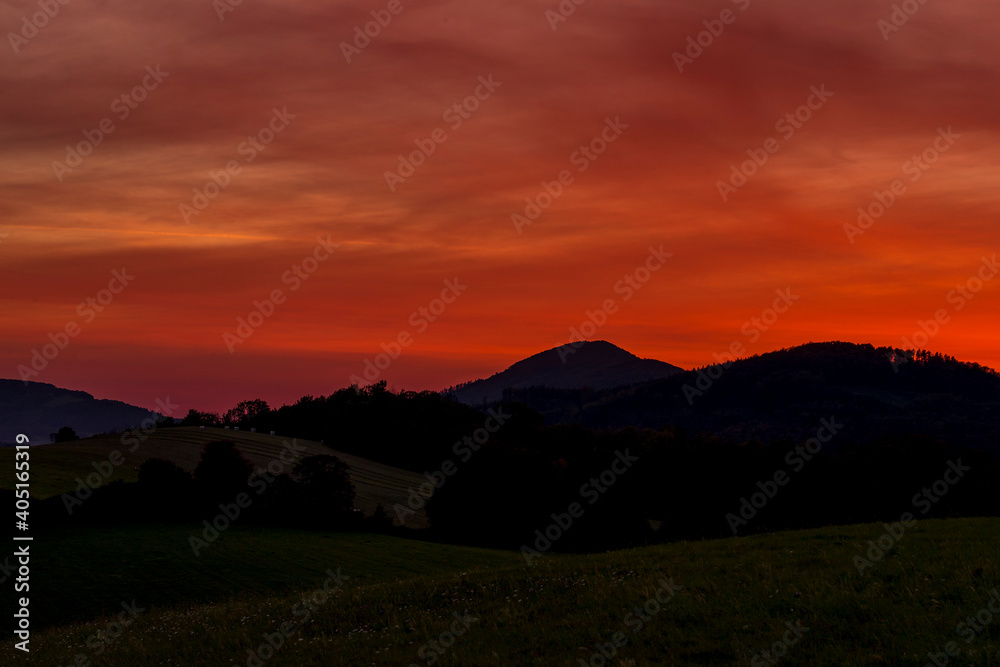 Beskydy mountains Kozlovice landscape with lots of hills and mountains on the horizon and colorful sunset with lots of clouds in the sky.