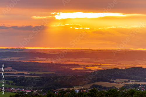 The landscape of the Beskydy Mountains from the viewpoint near Jicin during a colorful sunset and dark clouds in the sky and a view of the surrounding landscape. © Lukas