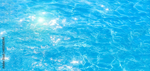 blue swimming pool,background of water in swimming pool. texture, blue water, bright rays of the sun. web panorama banner with copy space.