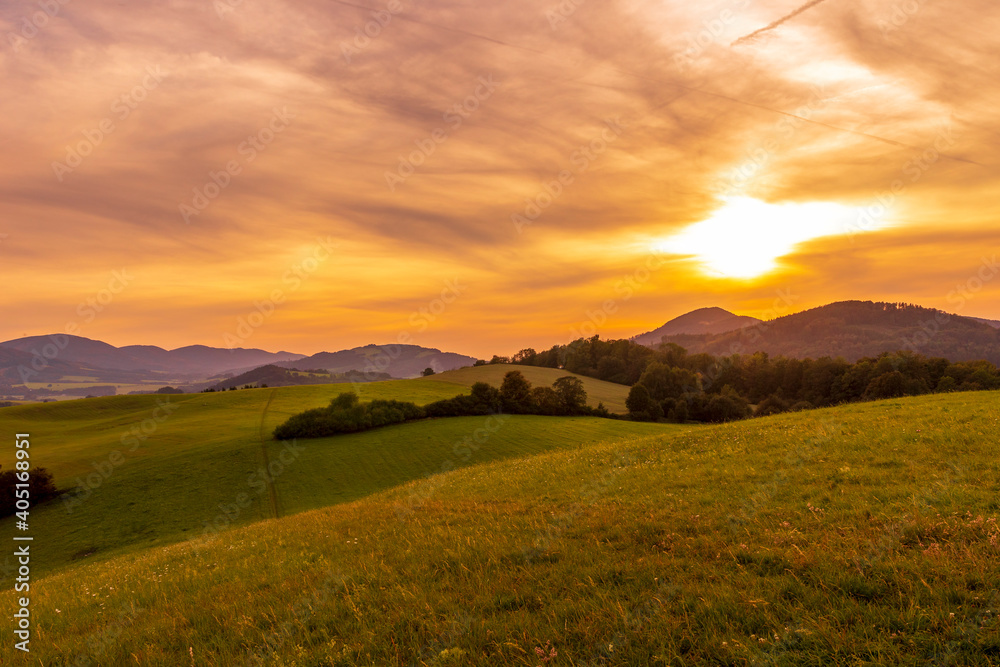 Fototapeta premium Beskydy mountains Kozlovice landscape with lots of hills and mountains on the horizon and colorful sunset with lots of clouds in the sky.