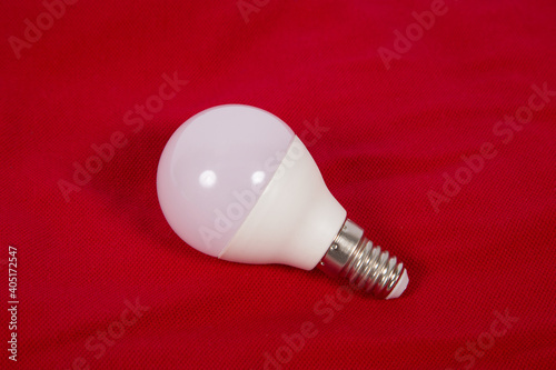 White electric light bulb on a red background.