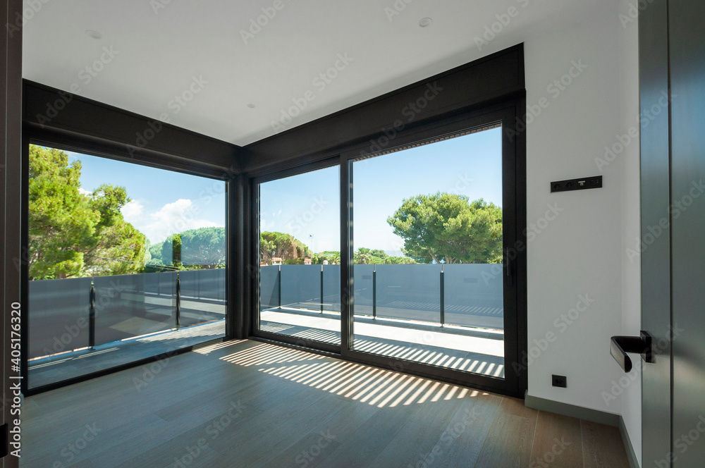 Fototapeta premium Empty room with large panoramic windows overlooking the sea. Room after major renovation.
