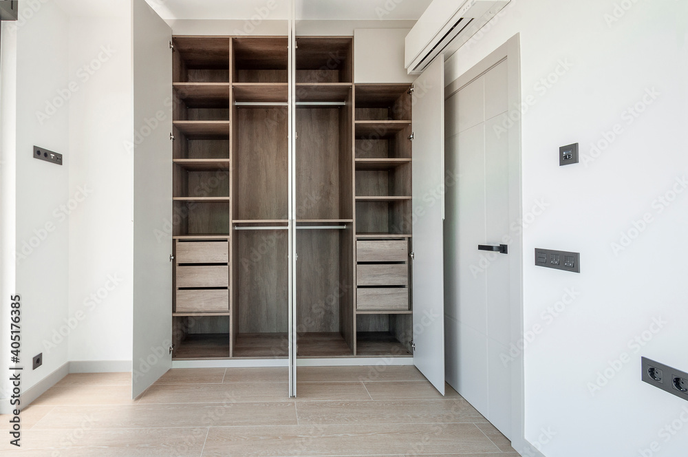 Built-in empty wardrobes with open doors. New house, empty rooms.