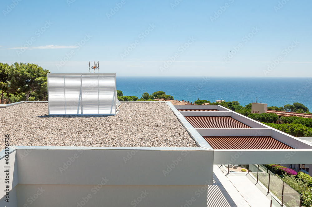 The roof of the house is covered with small stones. Crushed stone.