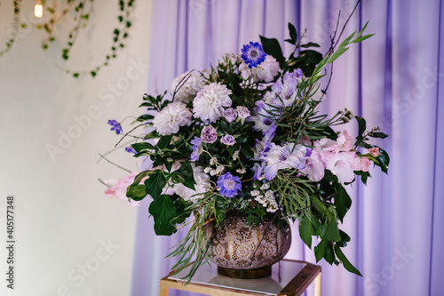 Composition of violet, purple, pink flowers and greenery on table. Home decor. Wedding decoration.