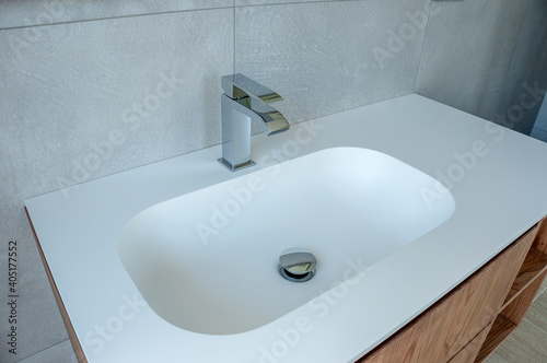 Modern white washbasin with mixer tap in bathroom.