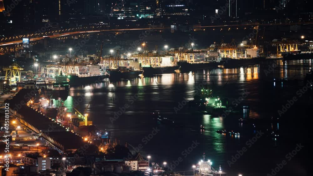 Time-lapse of Bangkok industrial port with cargo container, transport ship, and crane working at night. Logistic industry, freight transportation business concept. High angle view Time-lapse of Bangkok industrial port with cargo container, transport ship, and crane working at night. Logistic industry, freight transportation business concept. High angle view