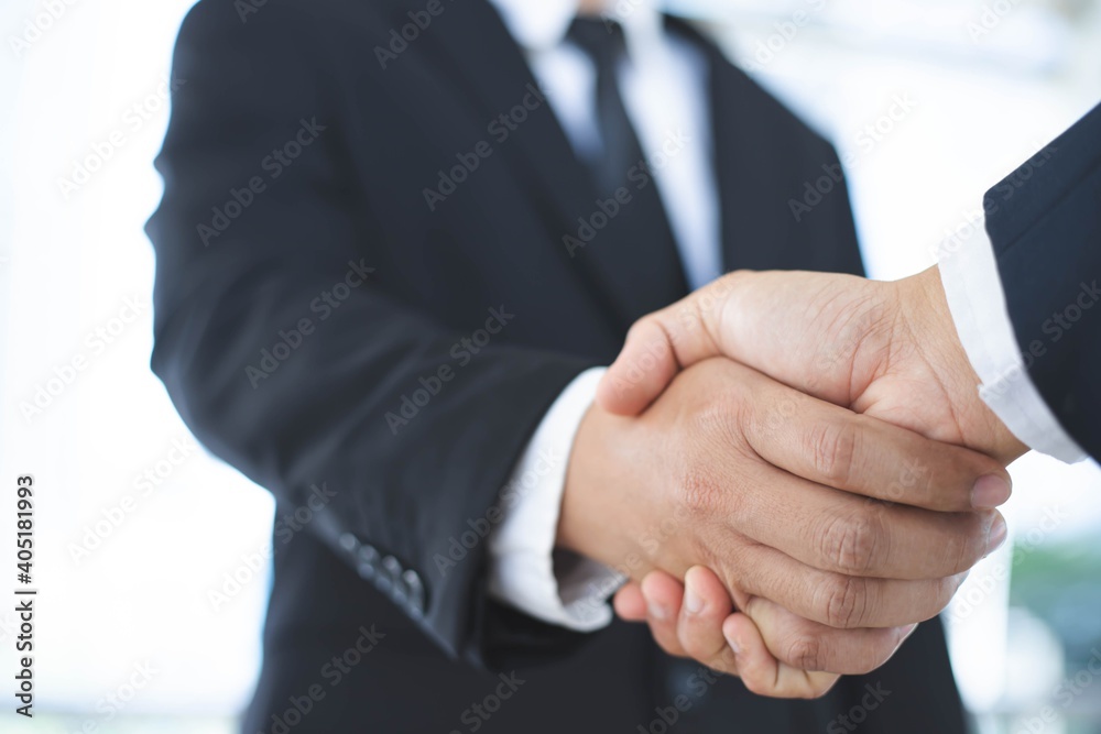 A close-up picture of a businessman shaking hands on a business cooperation agreement in the heart of the city. Concept of Cooperation business and success
