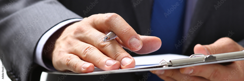Focused photo on pad that being in male hands, attentive businessman making notes while listening to conference Focused photo on pad that being in male hands, attentive businessman making notes while listening to conference