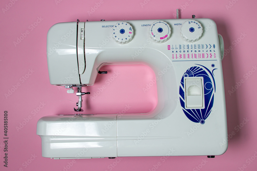 White sewing machine on a pink background. Electric sewing machine. Handmade tool. Sewing business.