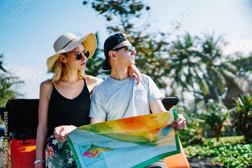 Young couple with map amidst green trees
