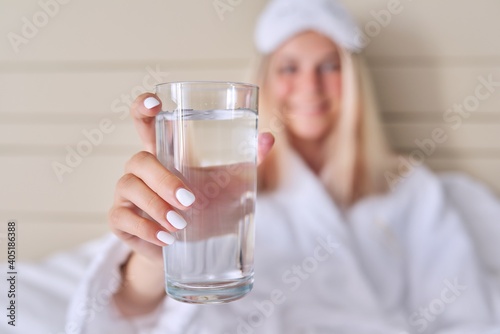 Glass of clean water close-up in hand of young woman